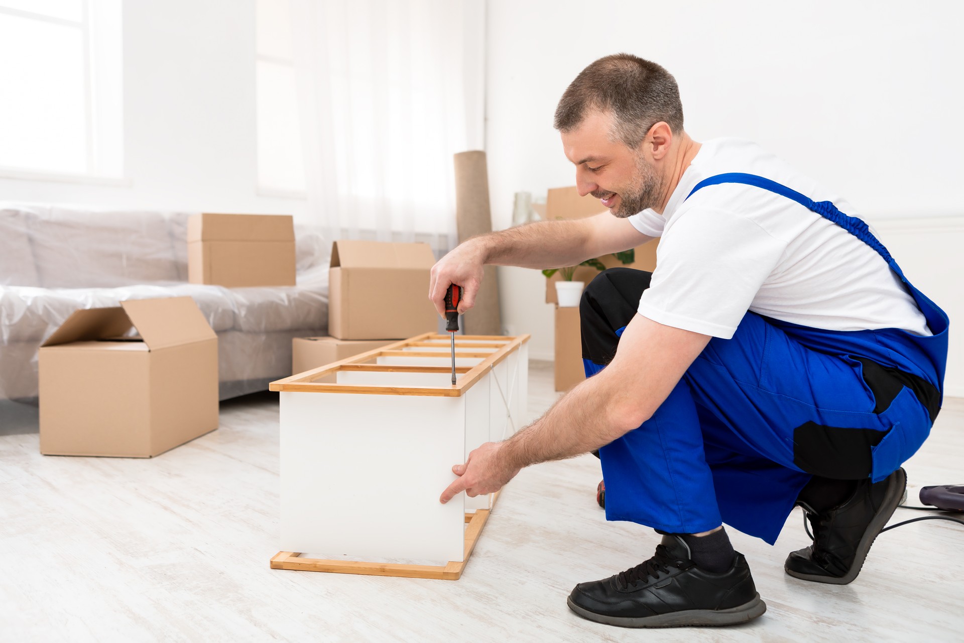 Male Furniture Assembler Repairing Wooden Shelf Using Screwdriver Indoor